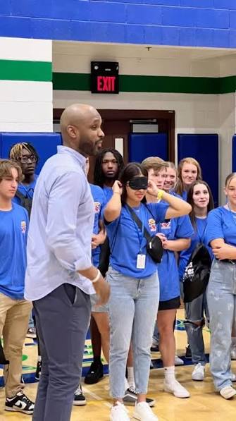 Omari Pearson leading a student leadership activity in a school gym